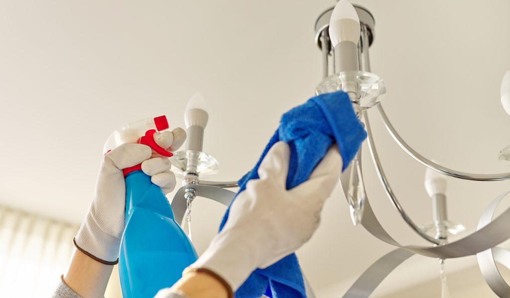 House cleaning, close-up of hands cleaning and polishing lamp